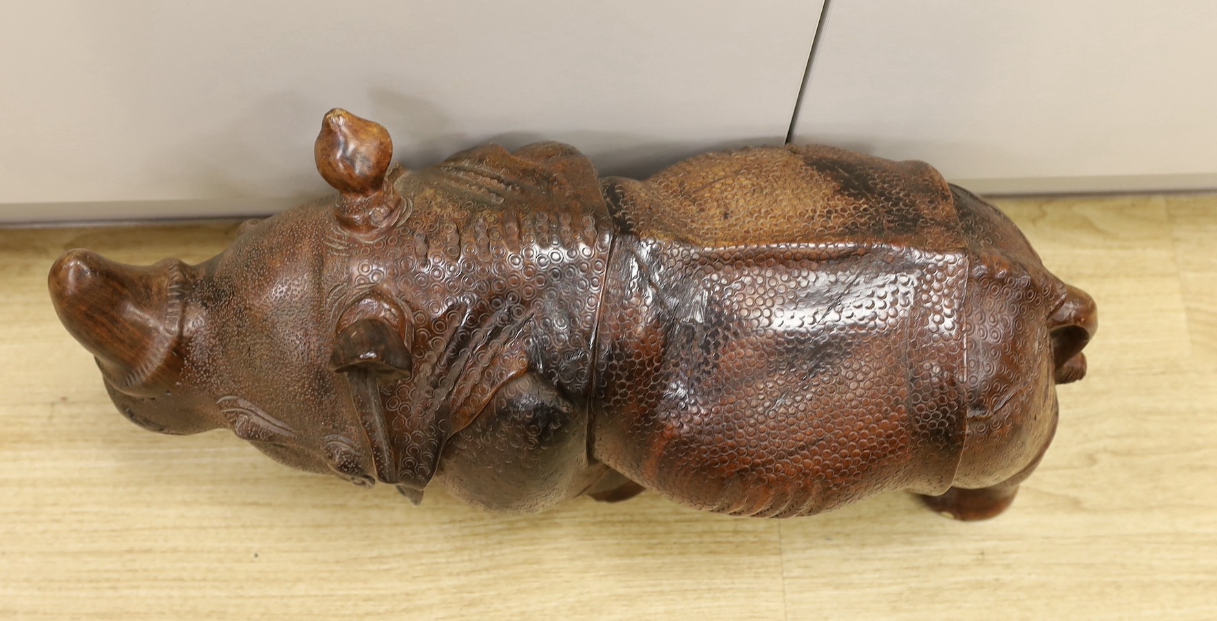 A carved wooden model of a rhinoceros, approximately 60cms long